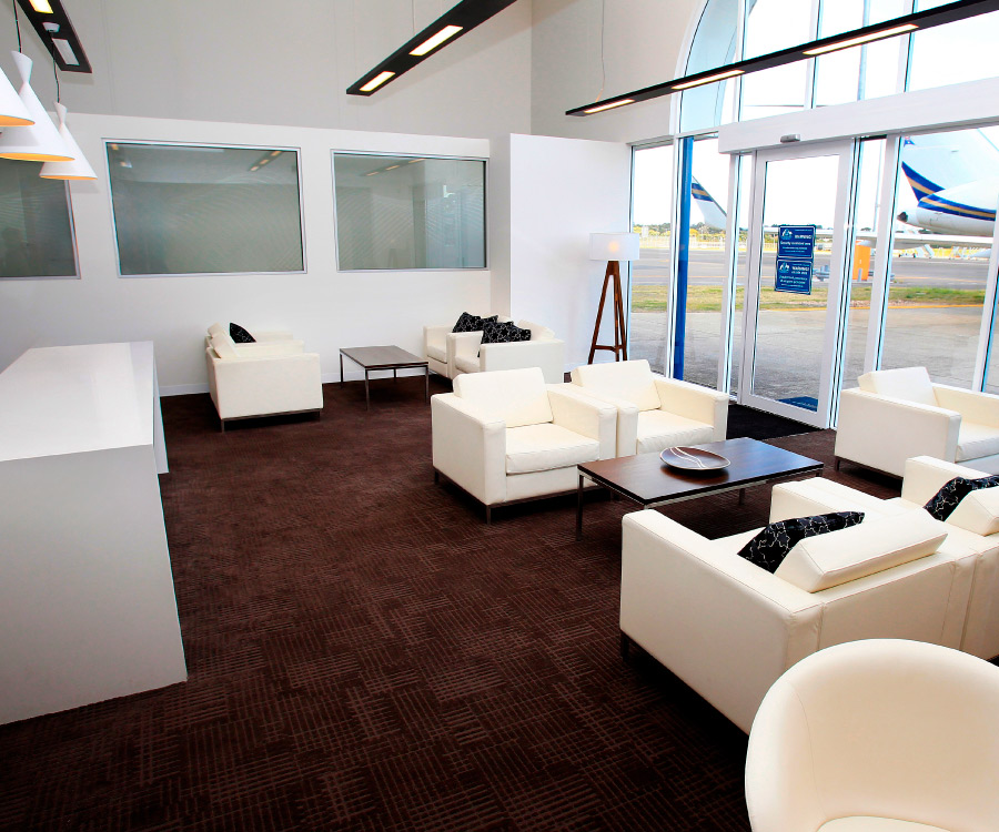 Our sophisticated ExecuJet Sydney FBO lounge adorned with luxurious beige couches and elegantly curated interiors