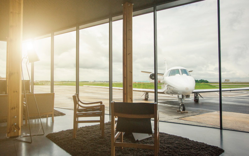 Scenic view of Brussels FBO apron showcasing a variety of aircraft, framed by expansive windows. ExecuJet AIN 2023 FBO Survey Honors.